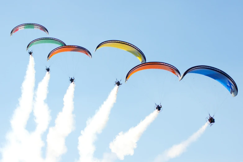 six kites in the sky with clouds