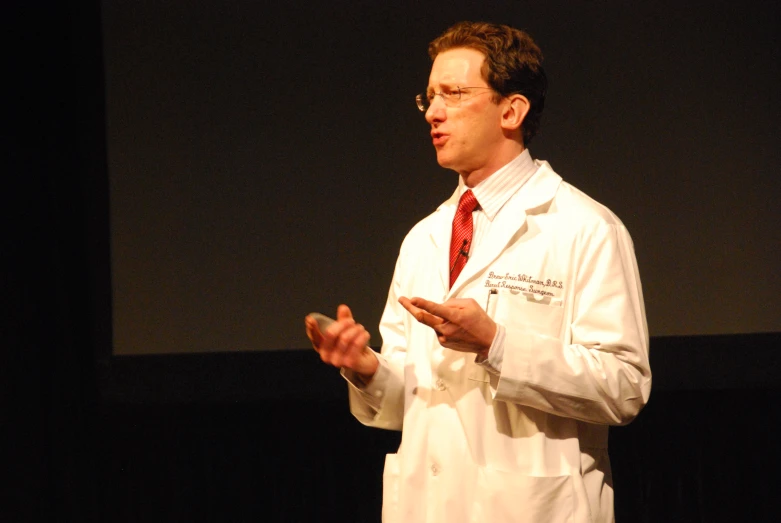 a man dressed in a lab coat speaking