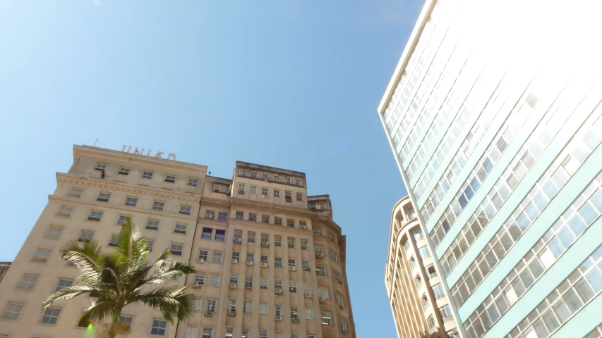 a tall building with two balconies and two trees next to it