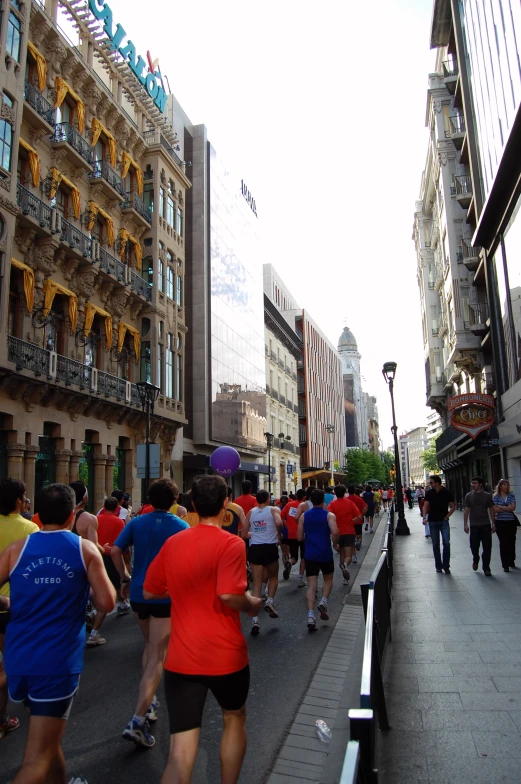 people are jogging down the street by buildings