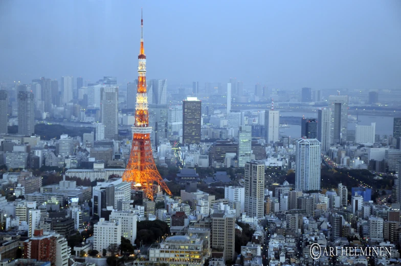 there are very tall buildings with a lit up eiffel tower in the foreground