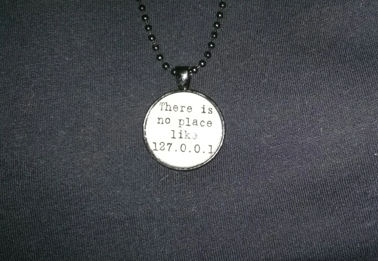 a necklace with a stamped metal pendant attached to it