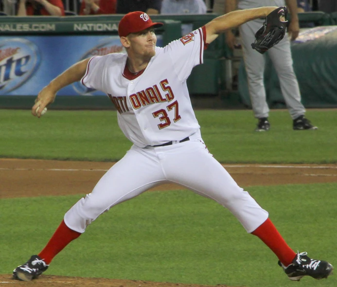 a professional baseball player throwing a pitch with his arm in the air