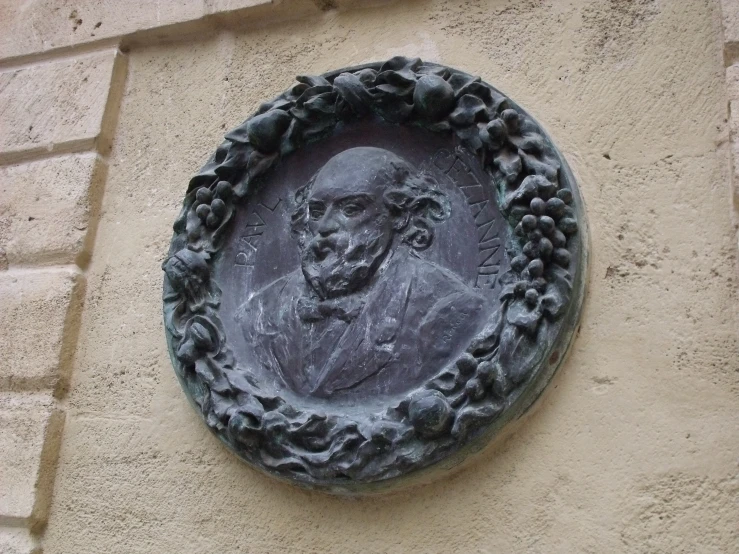 a wall that has a plaque on it with a picture of a man