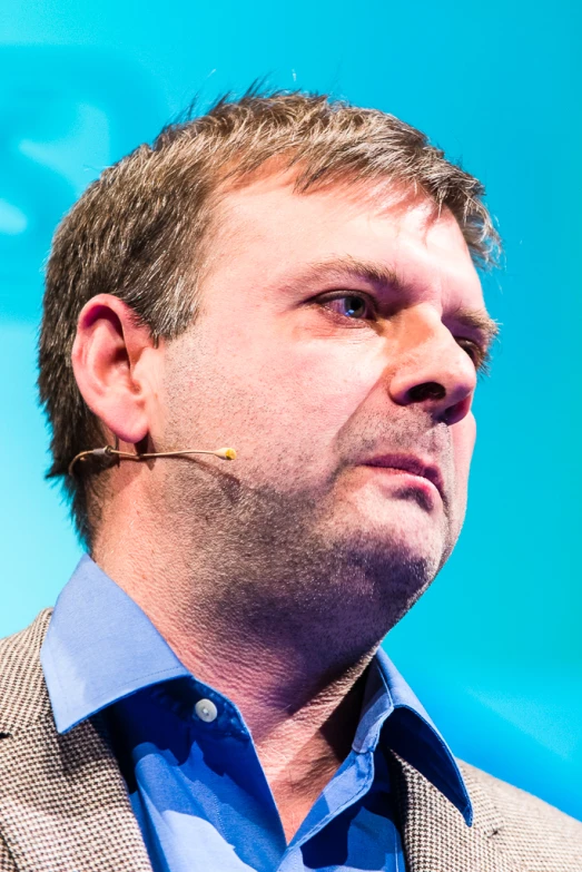 a man wearing ear pins looking off into the distance