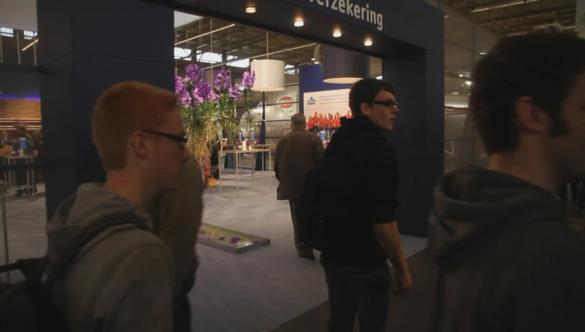 a man with glasses walking around a building