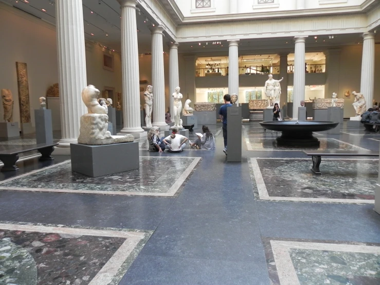 an art gallery with multiple marble pillars and sculptures