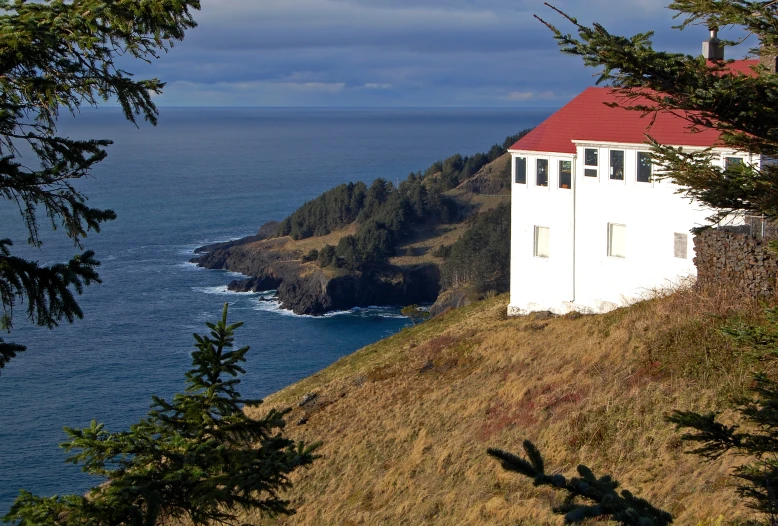 an outhouse sits on a cliff overlooking the ocean