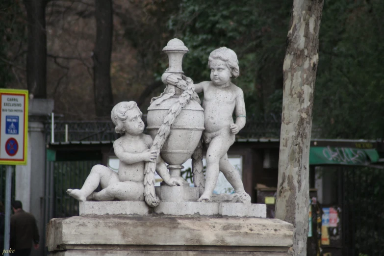 a statue of two boys and a boy sitting near each other