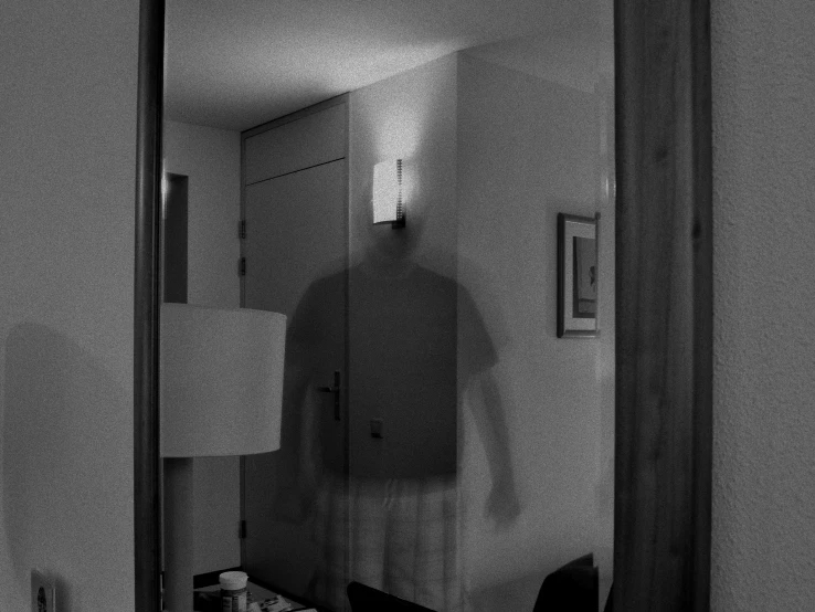 a man standing in a bedroom in front of a mirror