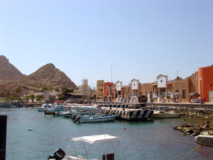 a group of boats are sitting on the water in a harbor near a mountain