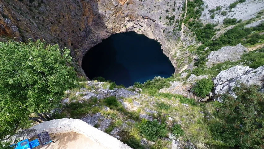 people sitting on benches in front of a large blue hole