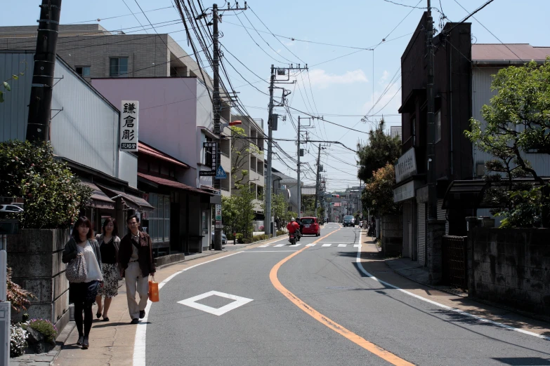 people are standing along the road by shops