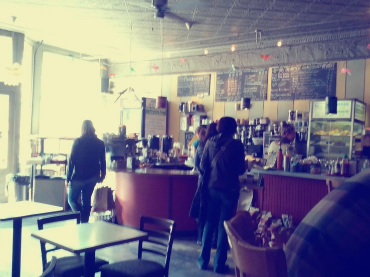 several people standing and sitting at a bar in an old building