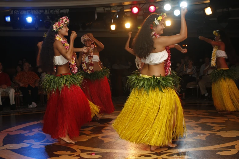 hawaiian dancers in orange skirts are doing a dance