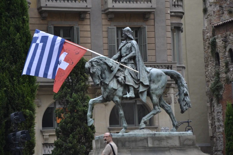 a statue with an flag and an apple on it in front of a building