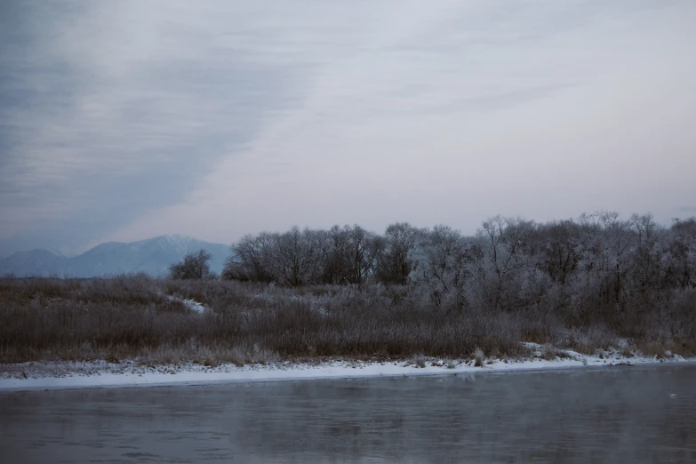 a river runs between the mountains and tree filled land