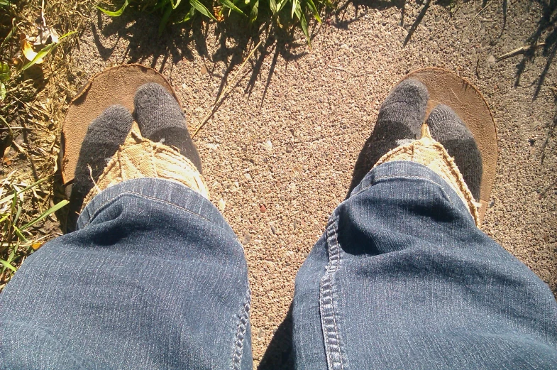 a man's feet wearing a pair of black jeans