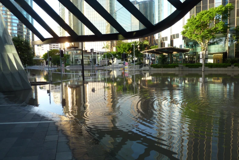 a wet and tranquil street next to a large building