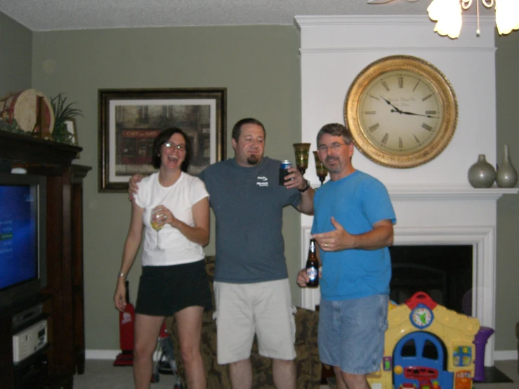 a man holding a glass next to two people in a living room