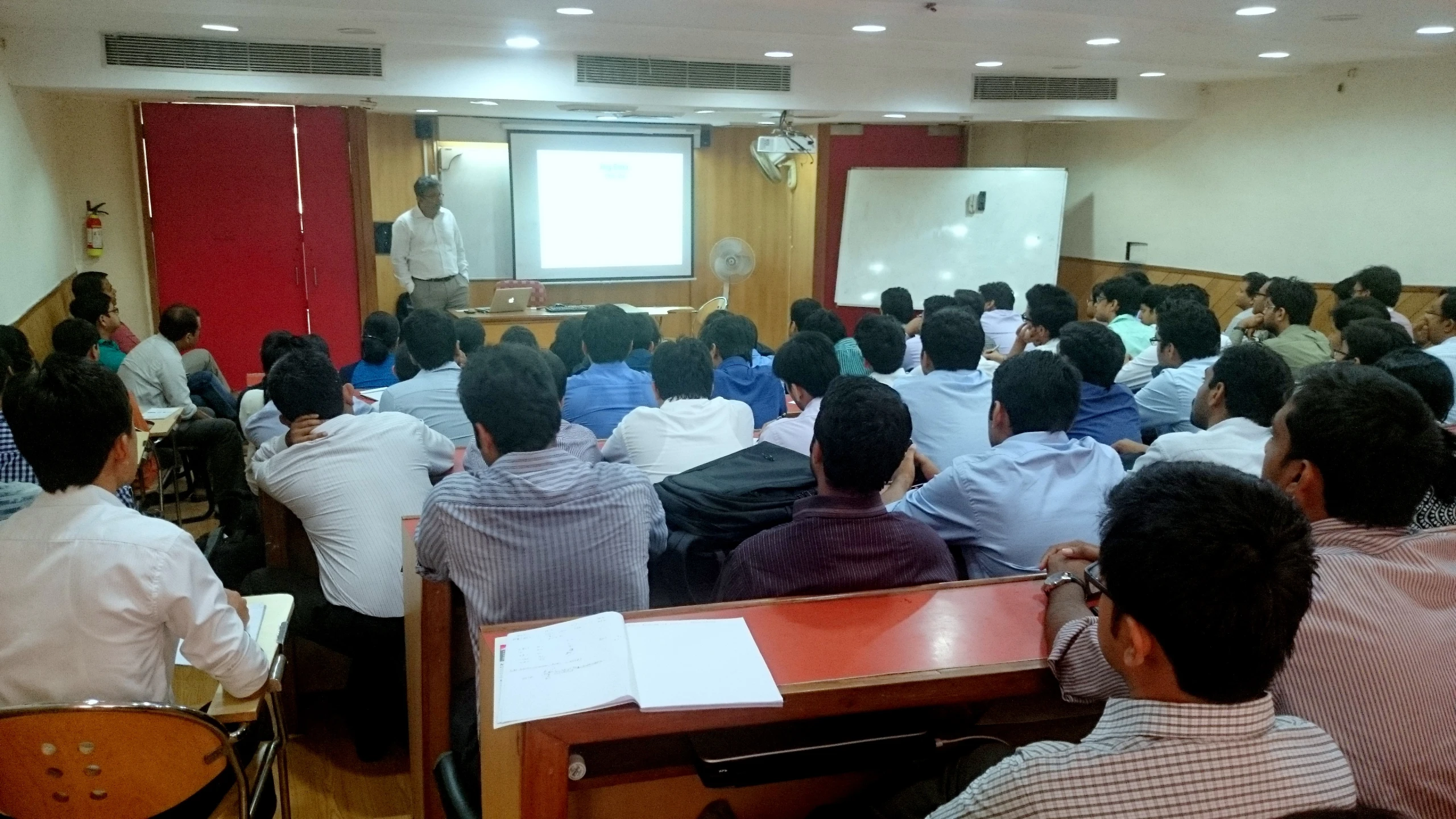 an audience watching a man presenting at a seminar