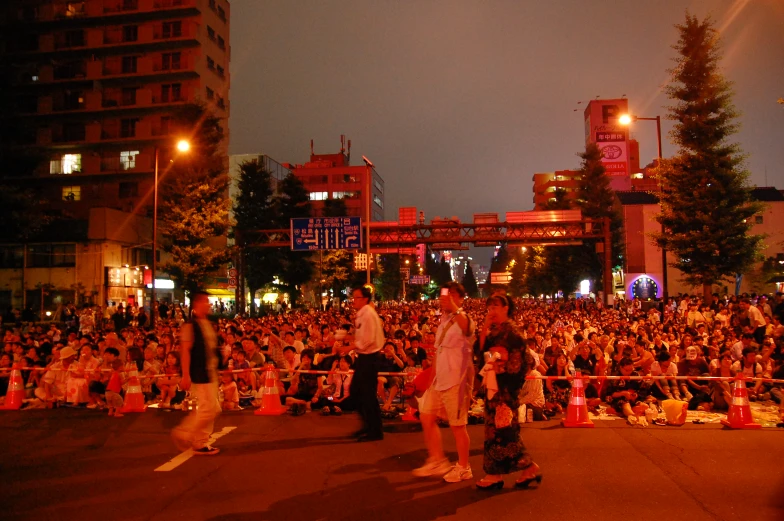 people in a crowd watching a skateboarder ride down a street