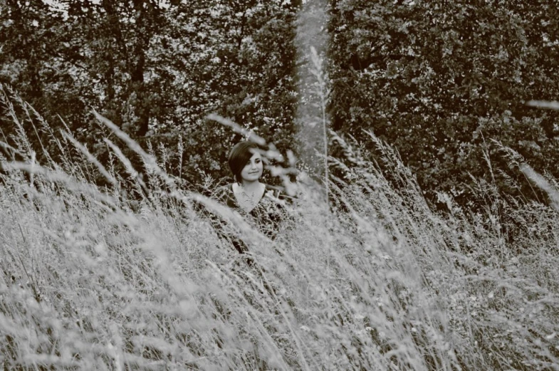 a woman is standing in the tall grass