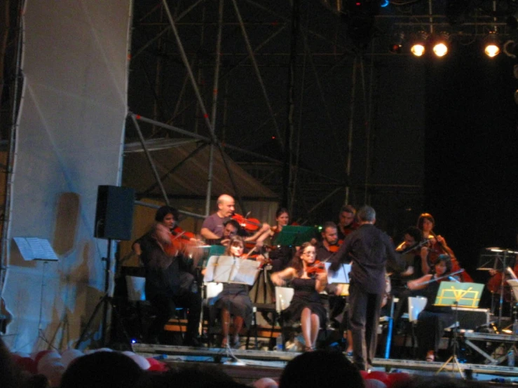 people are on a stage playing violin on the same side