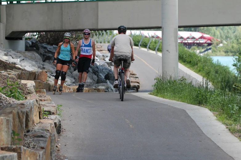 some people are riding bikes down a path by the water