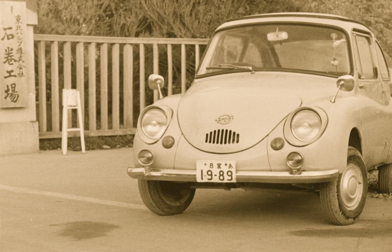 an old fashioned car parked on the side of a road