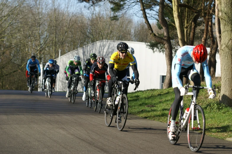 a group of bicyclists are riding down a road