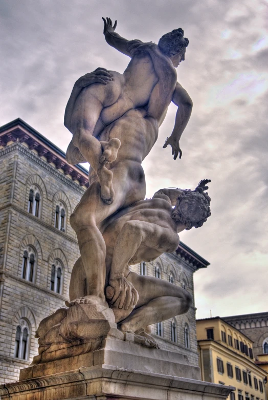 a statue of two  men in front of an old building