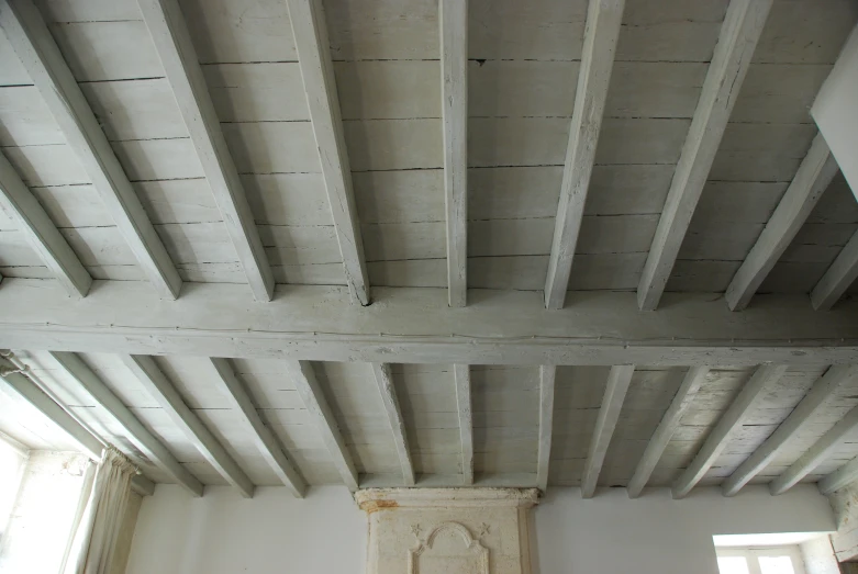a ceiling with exposed rafters and white plaster