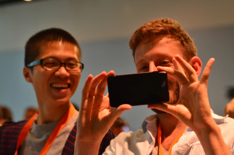 two men taking pictures with a camera phone