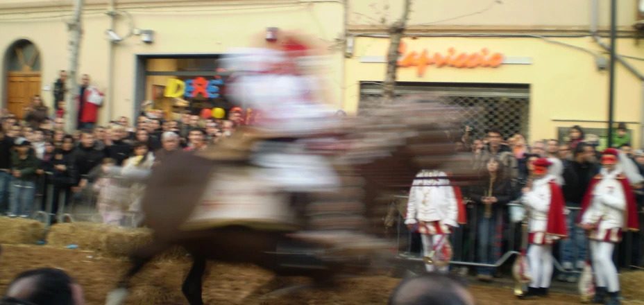 a blurry po of a man riding a horse in front of some people