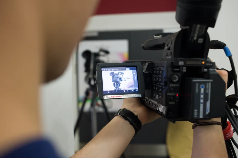 a person in blue is filming with his camera