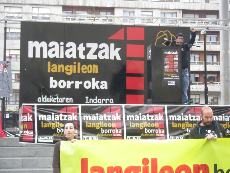 men holding up a sign standing on the top of a set of stairs