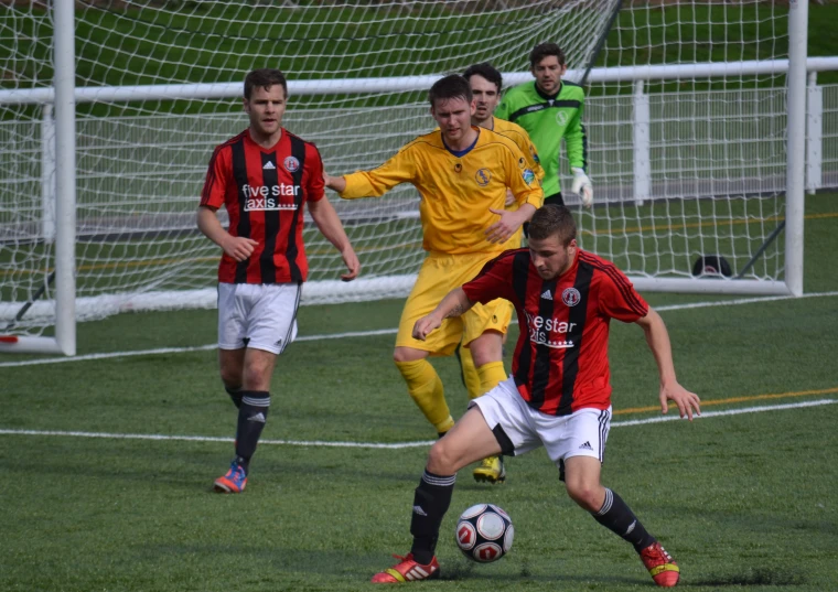 two soccer teams going after the ball on the field