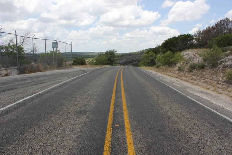 a paved road with no traffic and power lines