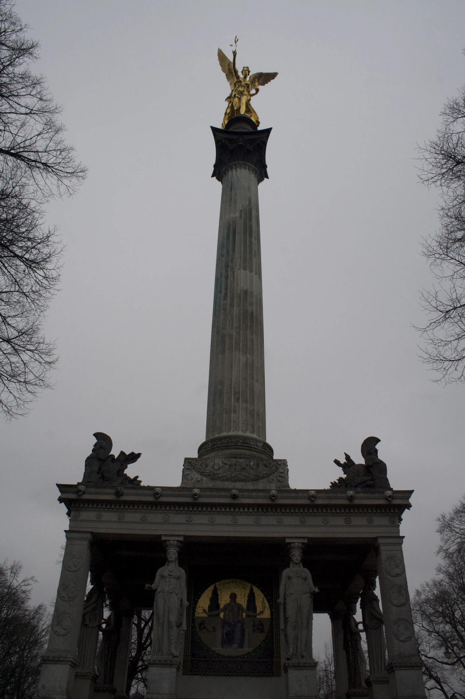 a monument with a gold angel statue top on it