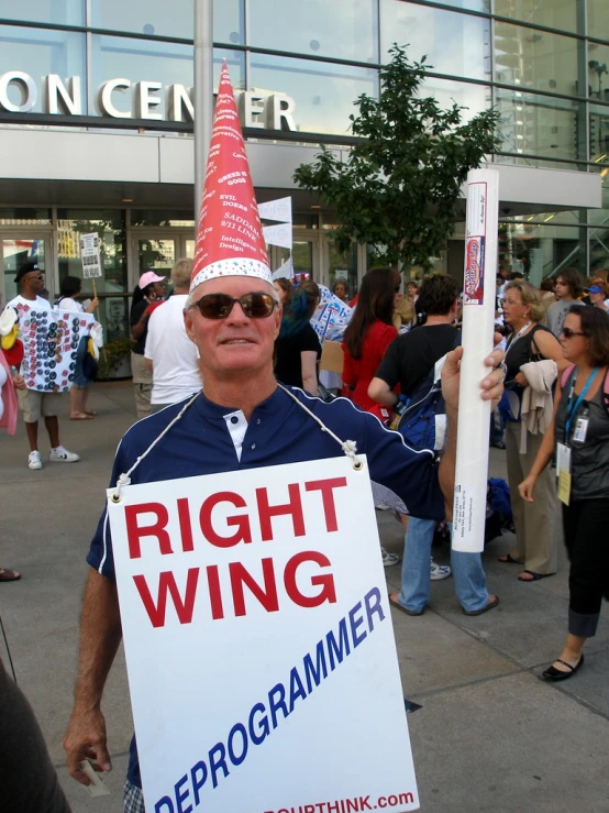 a man holding a sign with a large red and white sign saying right wing