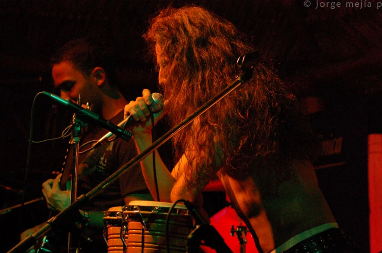 two men performing on stage with microphones in the air