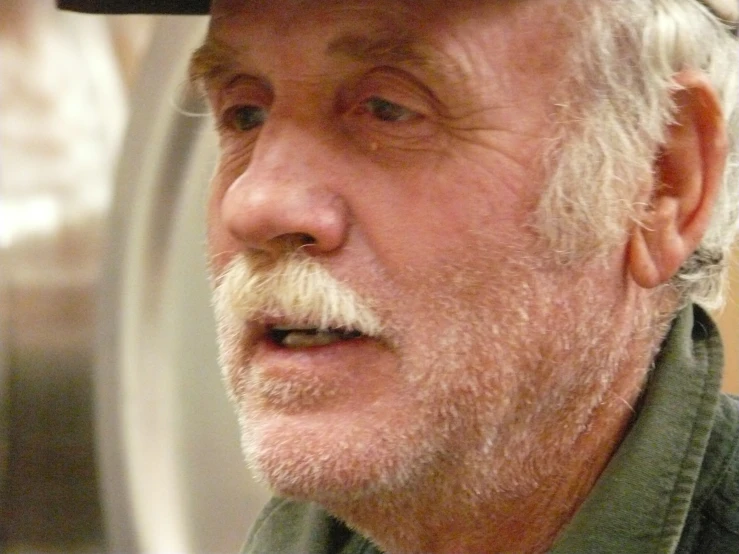 an older man wearing a baseball cap on his head