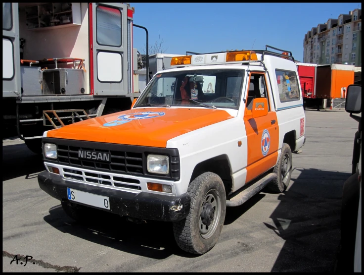 an orange and white tow truck is parked in the parking lot