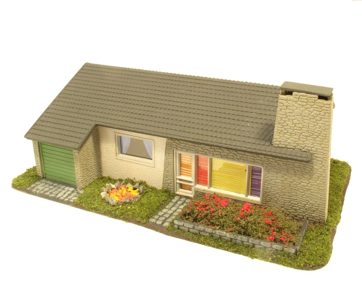 a model home with flowers, plants and a porch