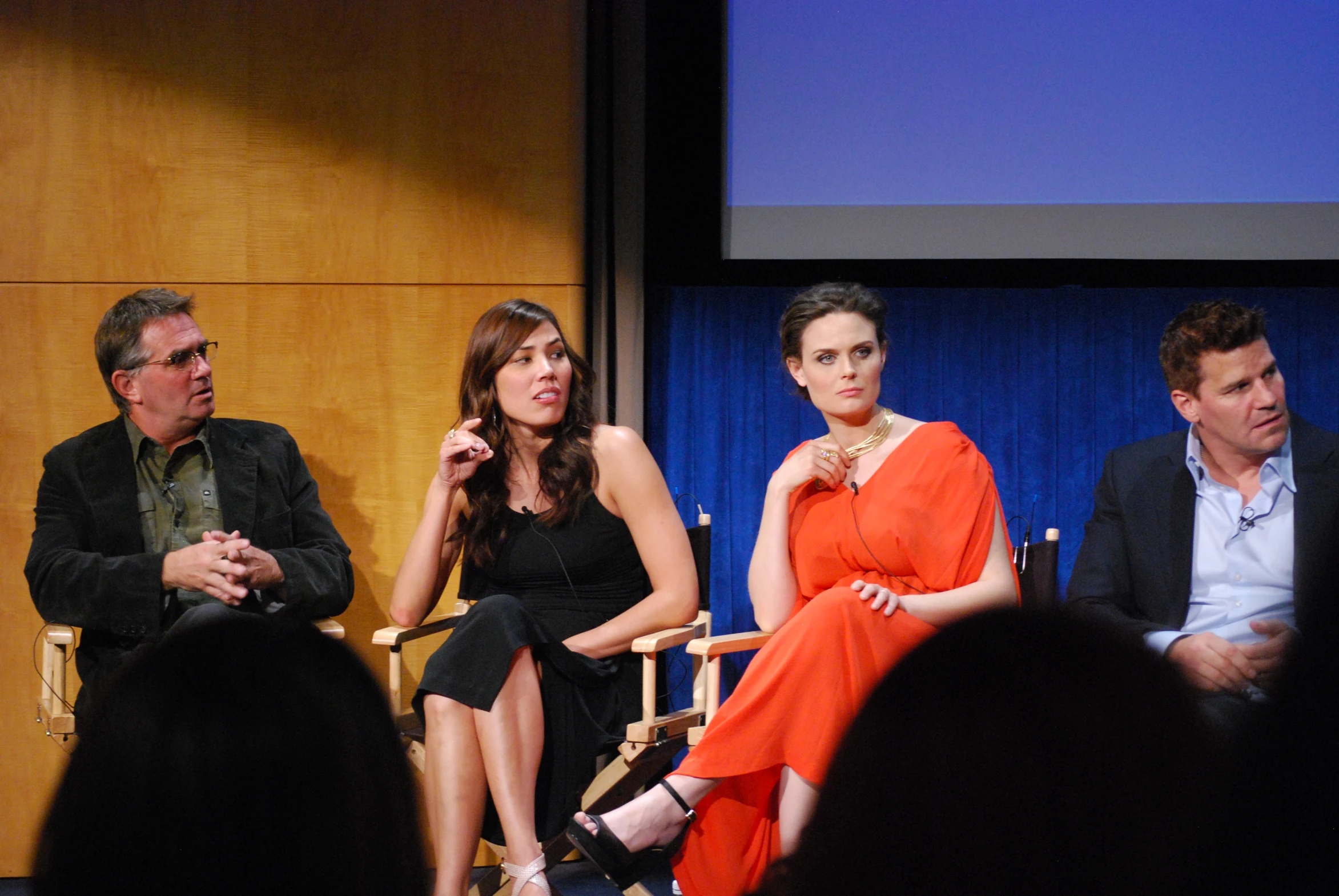 four people sitting in chairs at an event