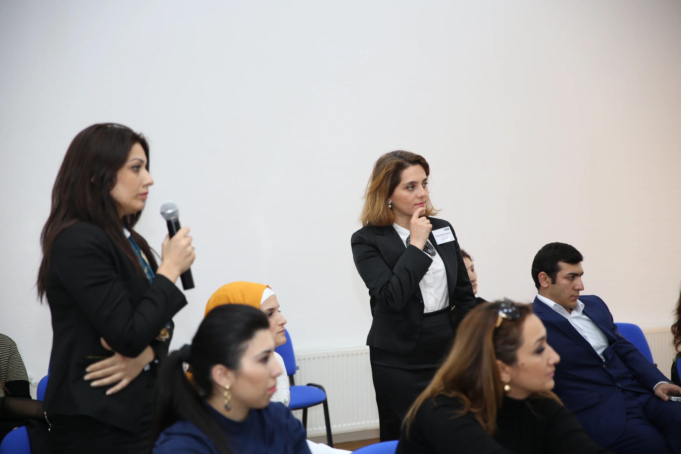 a woman speaking in front of other people