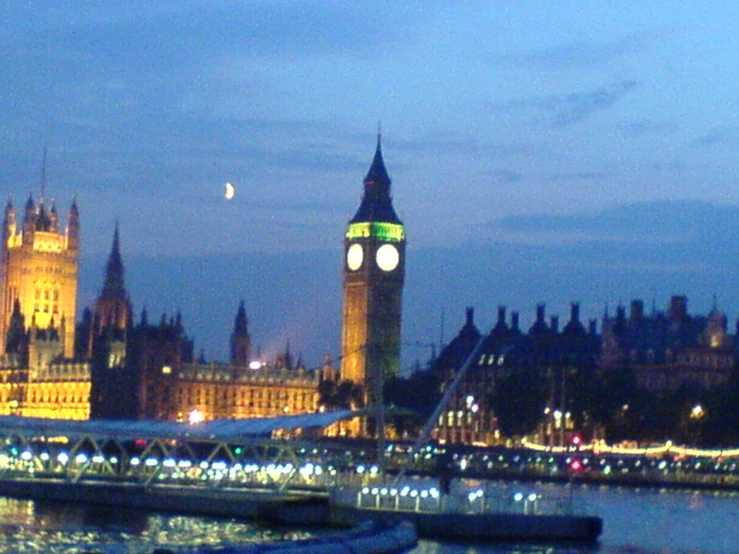 a tower clock in a city with the lights on