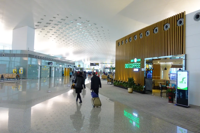 a group of people walking down a lobby next to an airport