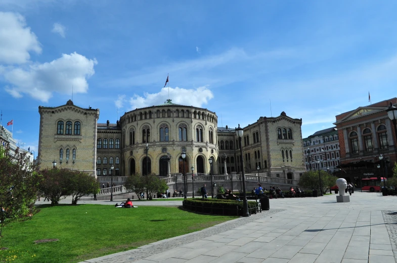 a view of an old building with a large circular garden in front